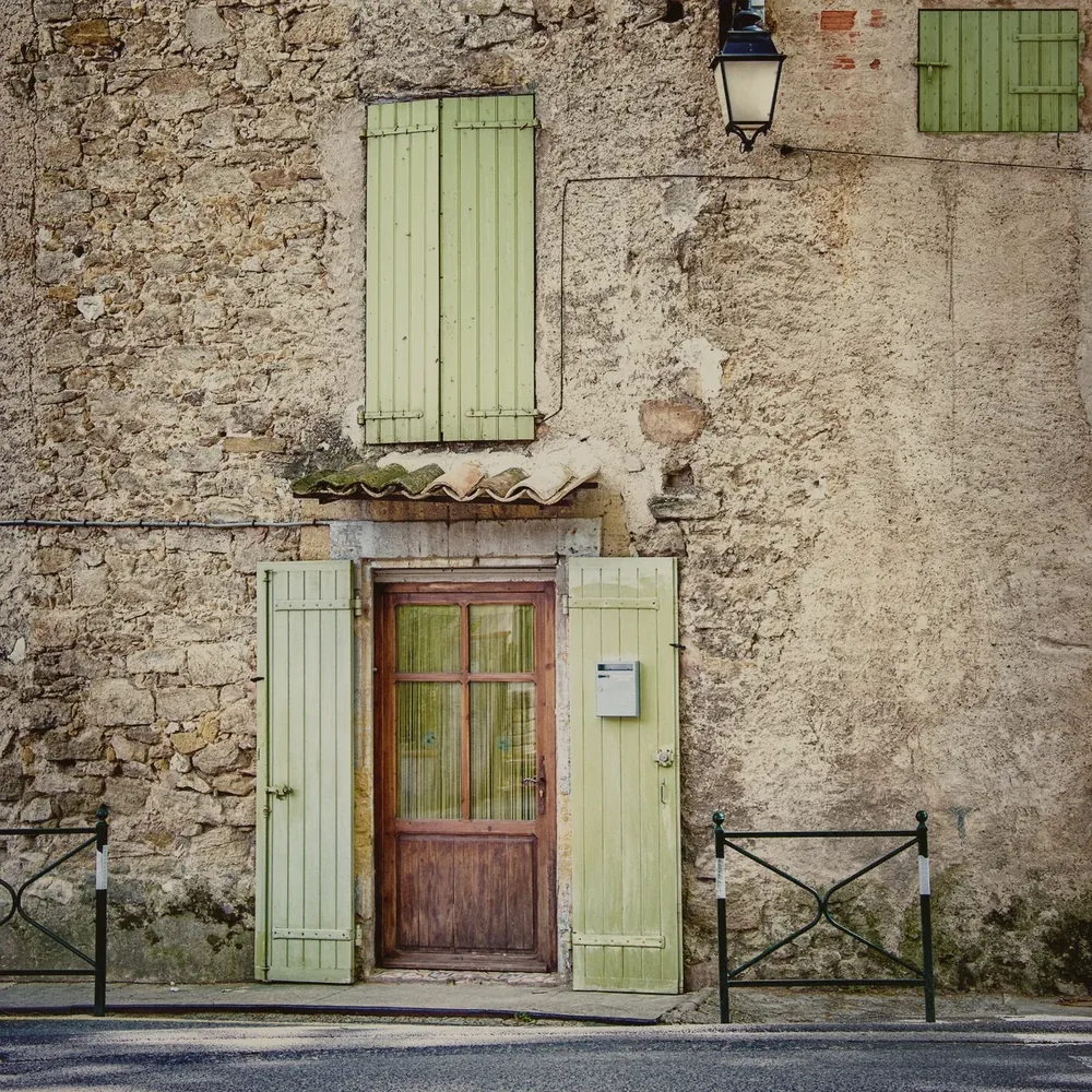 Façade en pierre aux volets vert amande, village de Provence