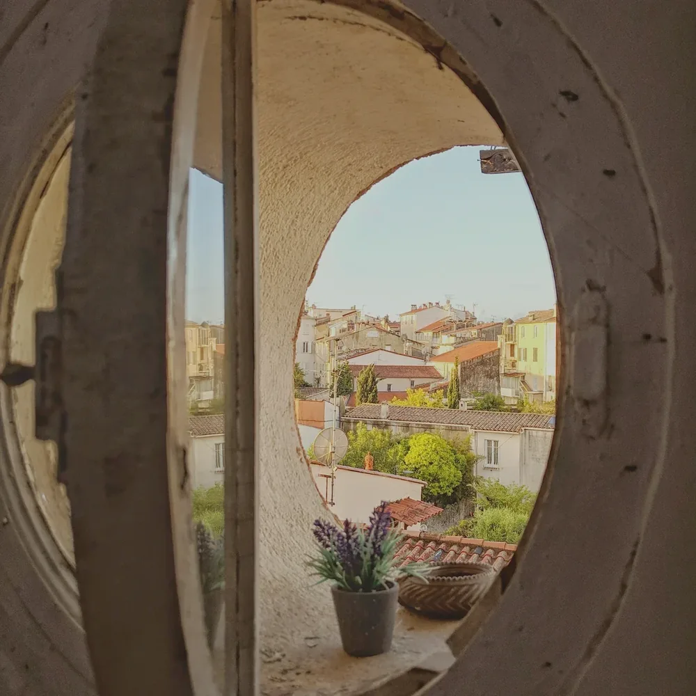Vue sur les toits d'un village par un œil-de-bœuf